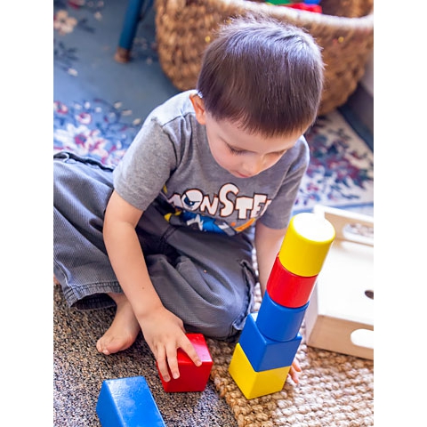 Child stacking colored blocks