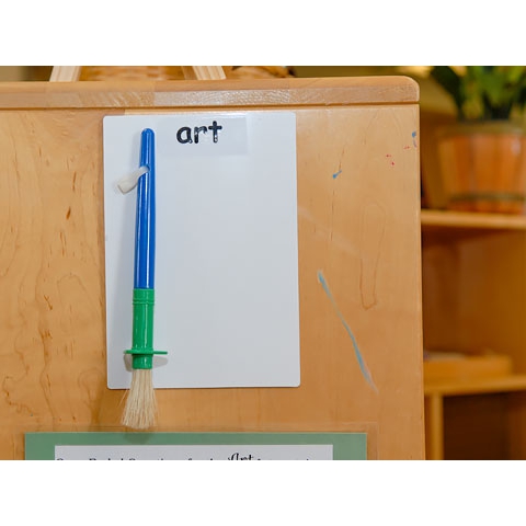 Sign that reads Art, with physical brush and text displayed near art area