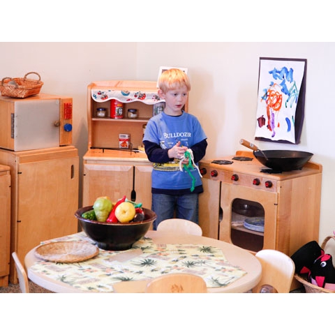 Child in play kitchen area