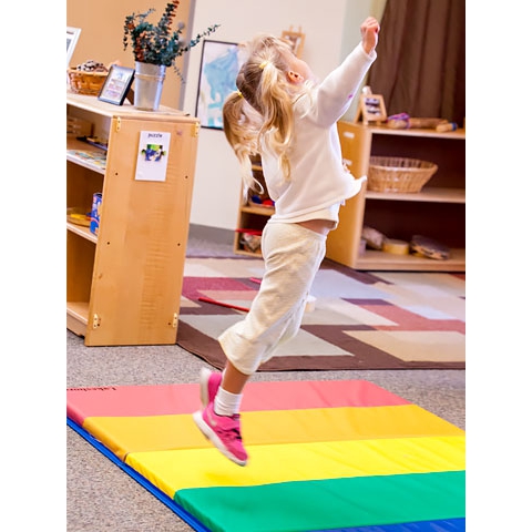 Child jumping on mat in large motor area