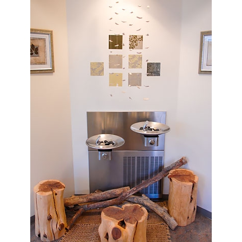 Art and wood pieces displayed around drinking fountain