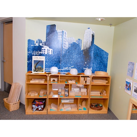 Floor shelving with blocks organized neatly in cubby holes and photo of city on wall
